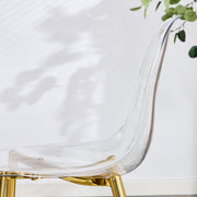 Table and chair set.Modern circular transparent tempered glass table, tempered glass tabletop, golden metal table legs.A Set of 6 Transparent Plastic Chairs with gold legs.